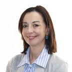 Head shot of Maria Grazia Sindoni, smiling, with shoulder-length dark hair, wearing a grey cardigan over a striped blouse.