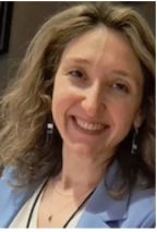 Head shot of Müge Satar, project PI, smiling with long brown hair in a blue blazer.