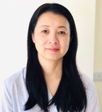 Head shot of Zhu Hua, with long straight dark hair, wearing a light striped shirt.